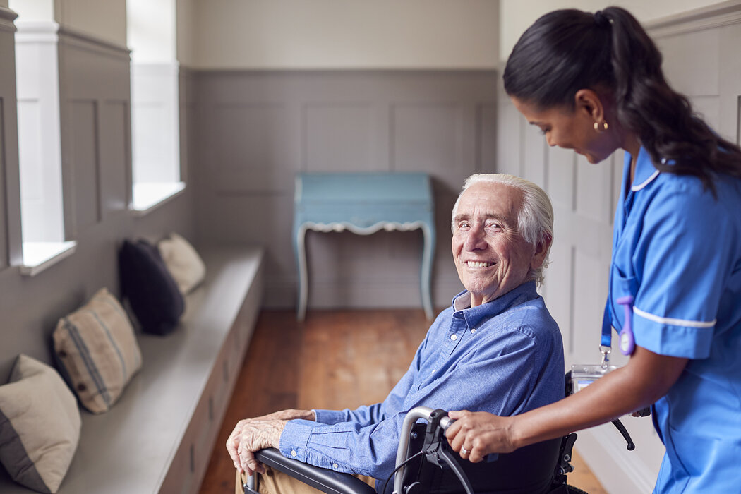 Senior im Rollstuhl mit Pflegekraft