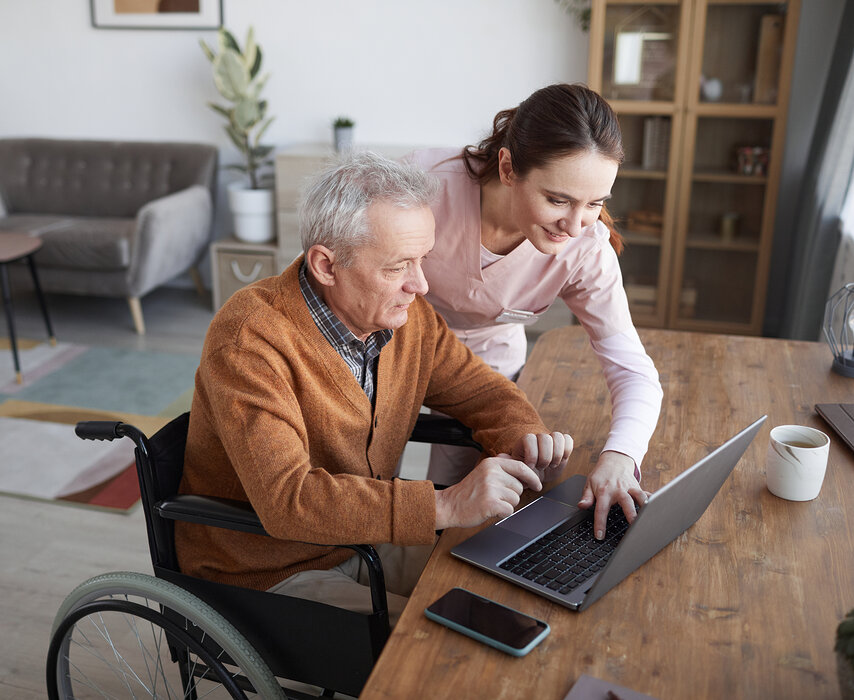 Senior bekommt Hilfe am Laptop