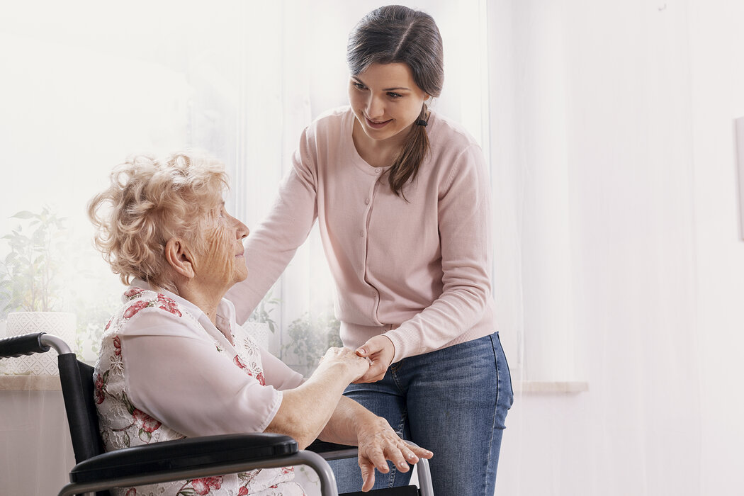 Seniorin im Rollstuhl mit Tochter